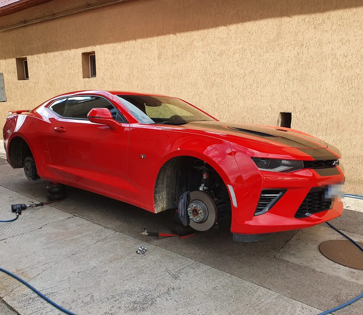 Chevrolet Camaro roșu cu roțile din față și din spate demontate