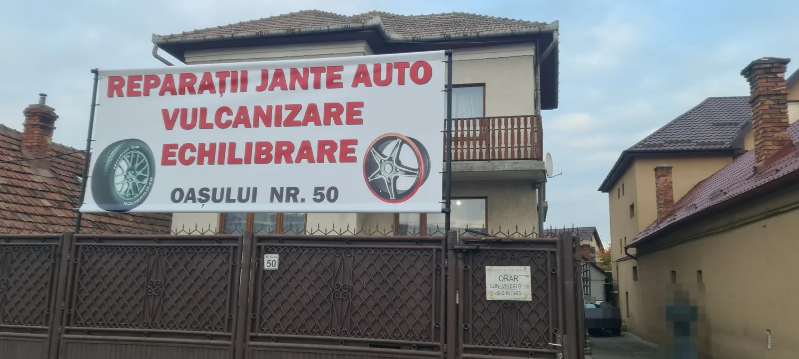 Fațada atelierului de pe strada Oașului 50, cu bannerul Reparații jante auto, vulcanizare, echilibrare